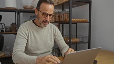 Mature hispanic man working on computer in office adjusts glasses while foc.. Stock Footage 302505461