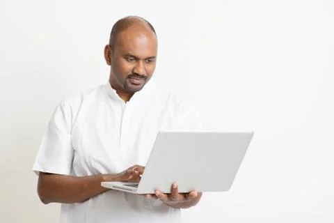 Mature Indian man using laptop Stock Photos