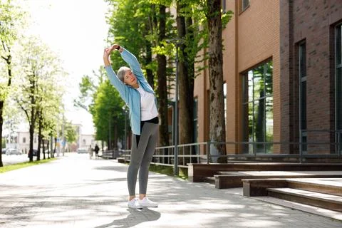 Mature Lady Doing Exercises While Listening to Music. Senior Runner Female Foto stock