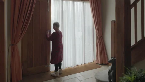 Mature lady opens front door Stock Footage 224664982