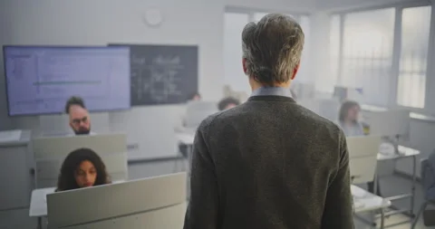 Mature Male Educator Teaching Coding Adult Learners in Bright Classroom Stock Footage 321251614