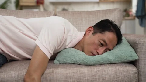 Mature male falling lying on couch in exhaustion Stock Footage 251121473