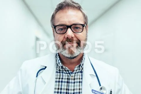 Mature male medical doctor standing in hospital Stock Photos