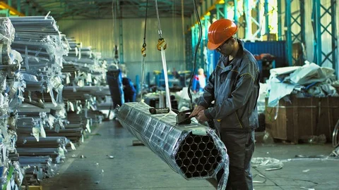 Mature male worker posing with a stack of steel pipes Stock Footage 89770106