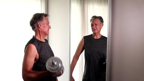 Mature man 60 plus working out in front of a mirror Video stock 219641875