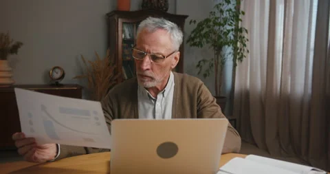 Mature man analyses statistics and works on project Video stock 229862638