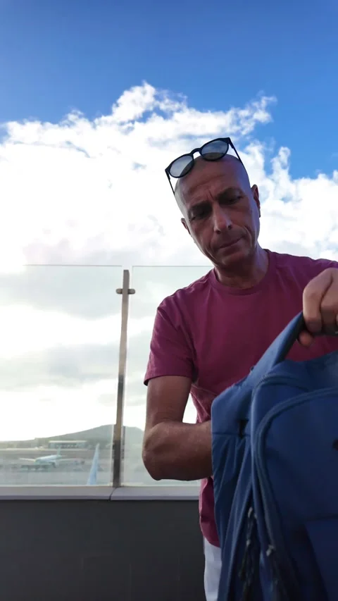 Mature man with a backpack arriving at Gran Canaria airport Stock Footage 345362311