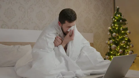 Mature man with beard got sick and works remotely on the computer at home Stock Footage 257551652
