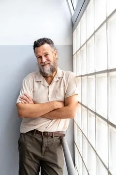 Mature man with beard looking at camera with arms crossed. Vertical. Stock Photos