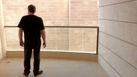 Mature man in black clothes gets the blues on his balcony Stock-Footage 108317239