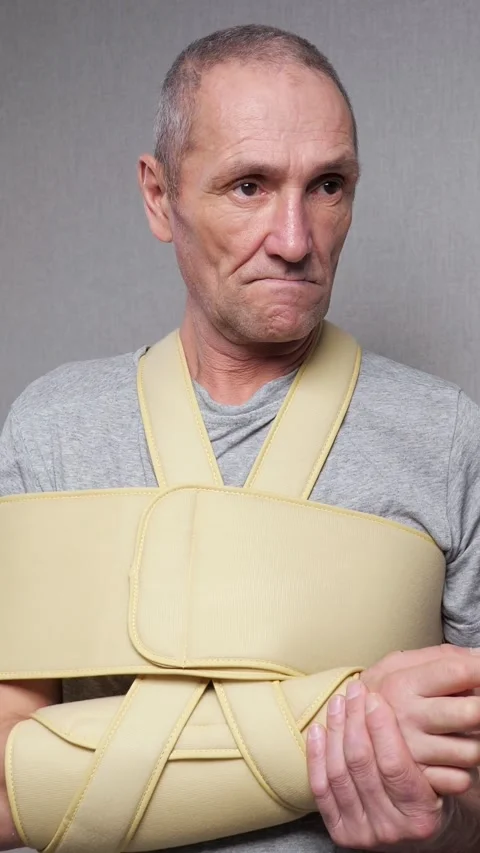 Mature man with a broken arm suffering from pain and wearing a medical shoulder Stock-Footage 340846136