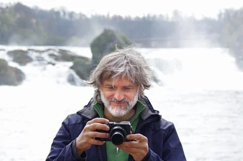 Mature man with camera at waterfall Stock Photos