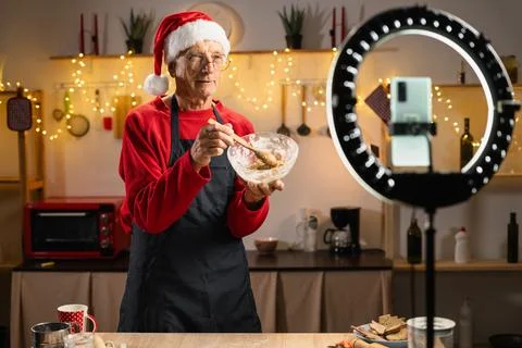 Mature man chef streaming virtual masterclass of cooking bakery christmas coo Stock Photos