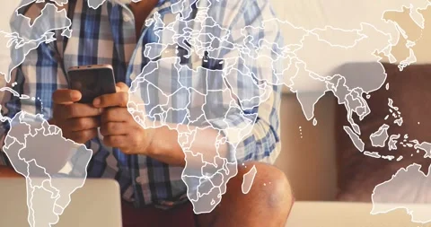 Mature man on couch tapping phone causing faint world map overlay covering frame Stock Footage 334040438
