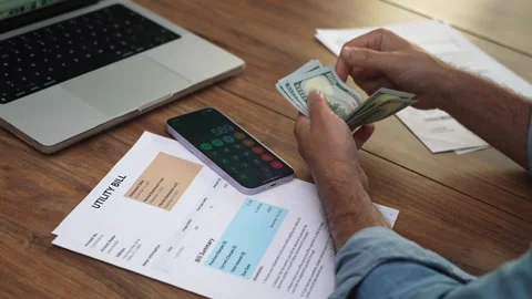 Mature man counts out folded stack of dollar banknotes on background of Stock Footage 289563397