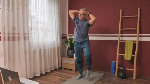 Mature man doing physical exercise on yoga mat at home Vídeos de archivo 319973231