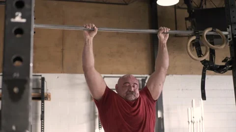 Mature man doing pull ups in gym Stock Footage 221040933