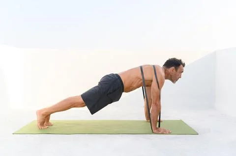 Mature man doing push-ups with elastic band Stock Photos