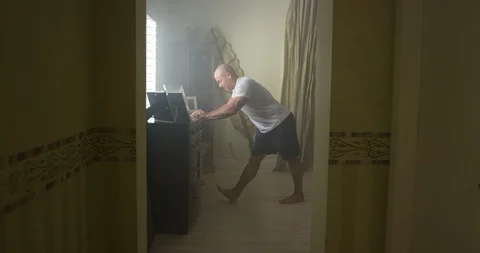 Mature man doing stretching exercise in bedroom at home Stock Footage 116373065