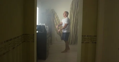 Mature man doing stretching exercise in bedroom at home Video stock 116373285