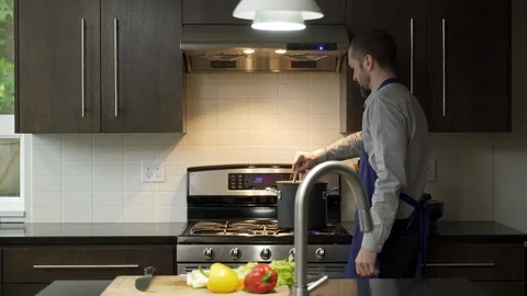 Mature man drinking red wine and preparing vegetables in kitchen, looking at 動画素材 88162895