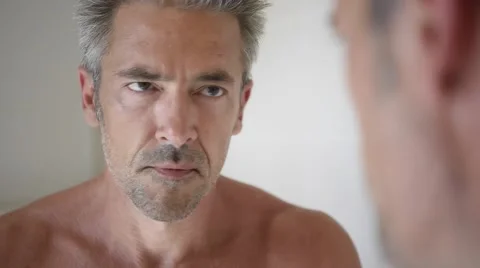 Mature man in front of mirror applying cream Stock-Footage 67558677