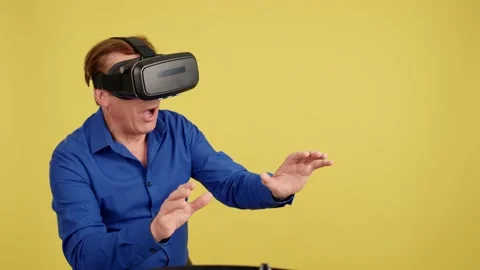 Mature man gesturing while using a virtual reality goggles Stock Footage 233521974