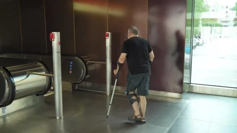 Mature man goes down the escalator to the subway using crutches Stock-Footage 281725895