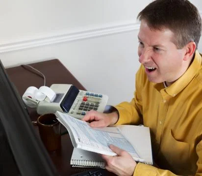 Mature man goes into rage while work on his taxes Stock Photos