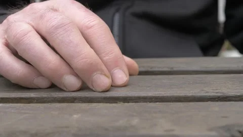 Mature man hands tapping on garden table in nervous wait Stock Footage 334775864