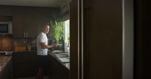 Mature man having breakfast in the kitchen at home Stock Footage 116371099