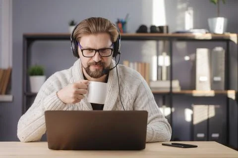 Mature man in headset using on laptop at home Stock Photos