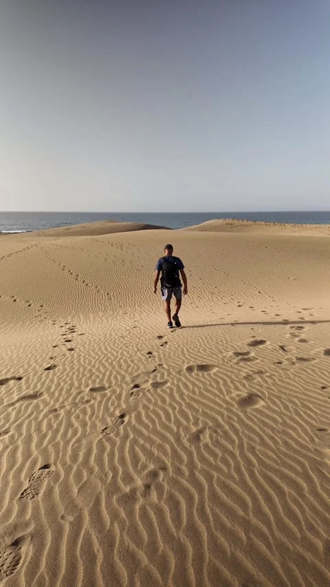 Mature man hiking with a backpack in a sandy desert Stock Footage 345093070