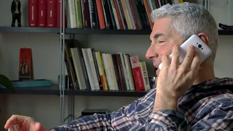 Mature man at home using smartphone and drinking alcohol: side portrait  Stock Footage 73167888