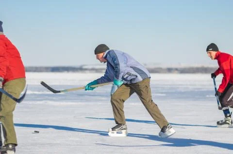 Mature man leading pack while playing hockey Stock Photos