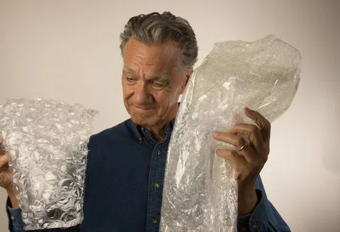Mature Man looking over some Bubble Wrap Stock Photos