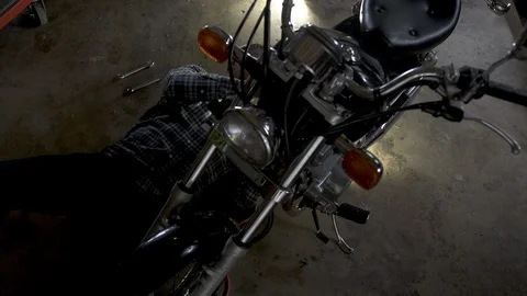Mature man lying underneath and working on motorbike. 動画素材 88031252