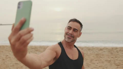 Mature man makes selfie while standing on seascape background Stock Footage 237318394