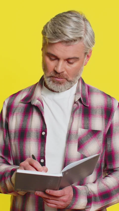 Mature man making notes writing thoughts with pen into notepad notebook diary to Stock Footage 348055238