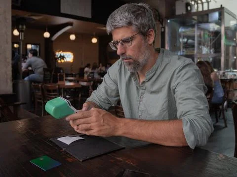 Mature man paying bill using credit card reader Stock Photos