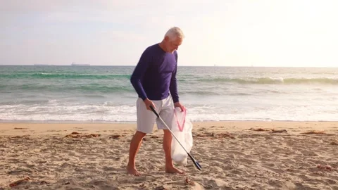 Mature Man Picking Up Trash At The Beach Stock-Footage 293519164