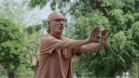 Mature Man Practicing Breathing Exercise in City Park Vídeos de archivo 279213688