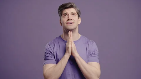 Mature man praying with palms on violet background. Guy begs satisfy desires Stock Footage 324820426
