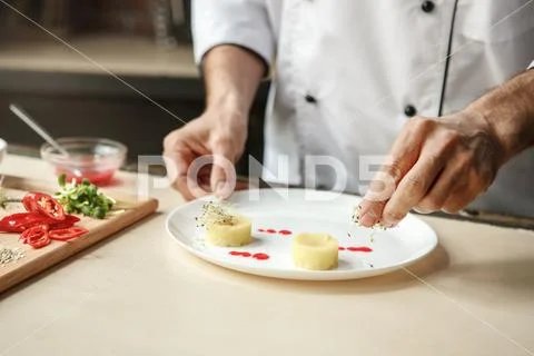 Mature man professional chef cooking meal indoors Stock Photos
