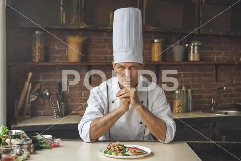 Mature man professional chef cooking meal indoors Stock Photos
