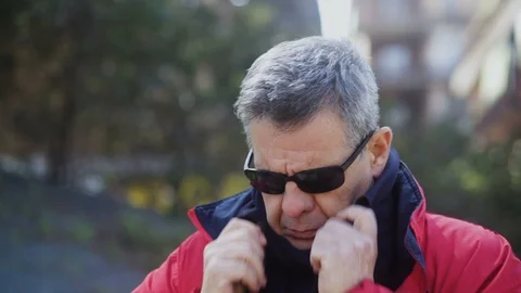 Mature Man in a red Jacket and tucks her Scarf in the wind in the Park Stock Footage 100947660