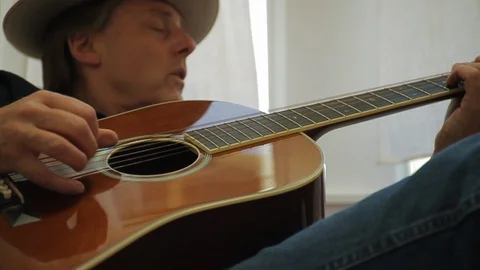 Mature man singing while playing an acoustic guitar. Stock-Footage 88438350