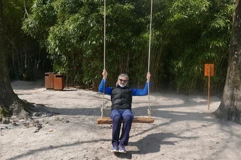 Mature man on a swing Stock Photos