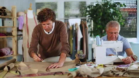 Mature man tailor at work, other man draw dress pattern on paper Stock Footage 321325603