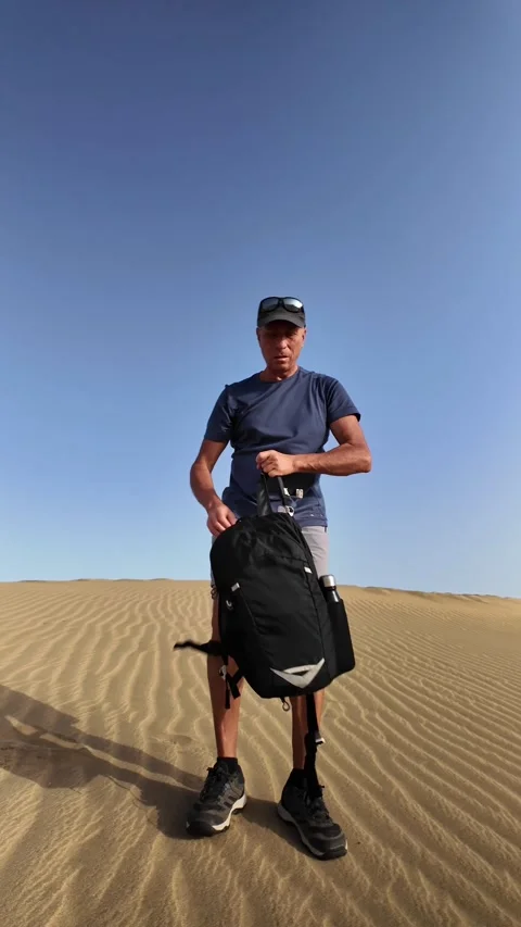 Mature man taking a break during a hike in the desert Stock Footage 345093182